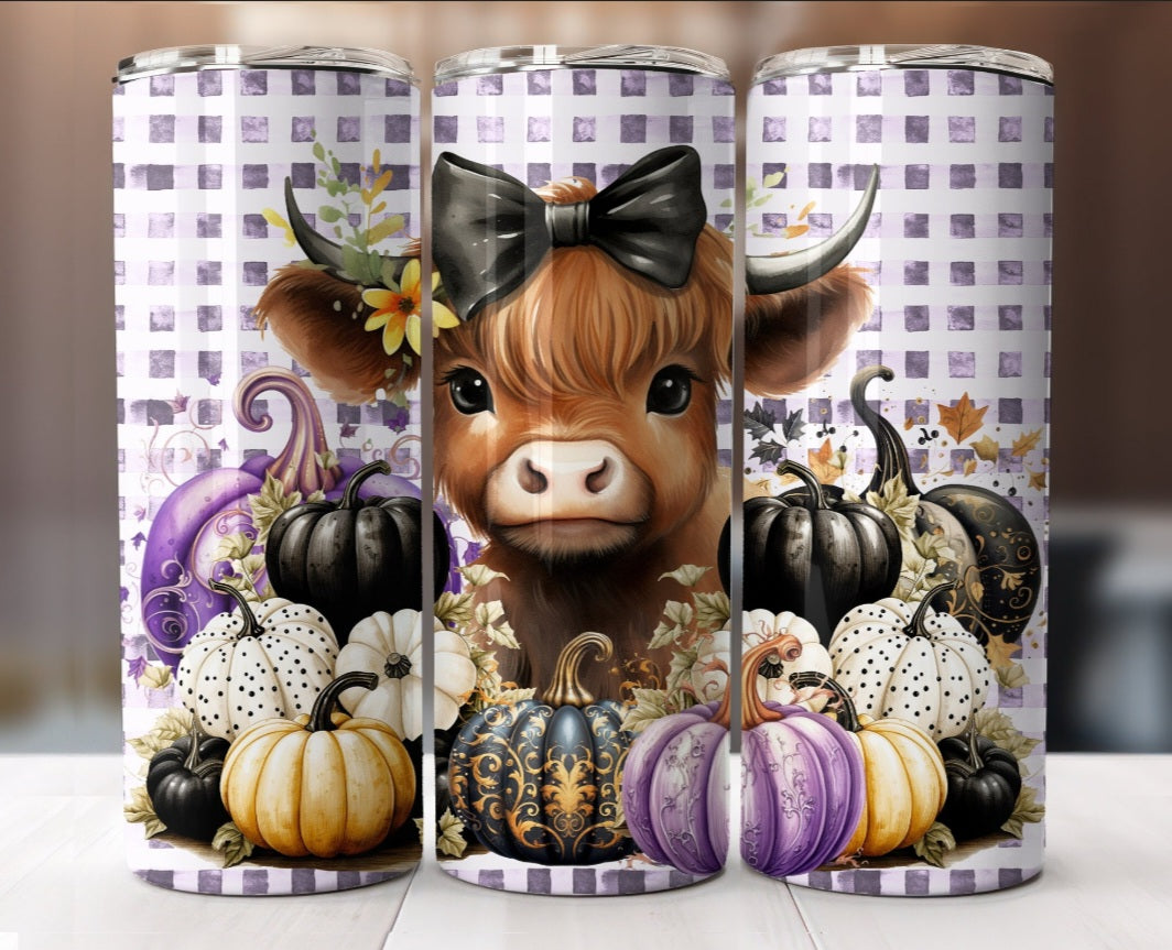 Cute Highland cow with pumpkins